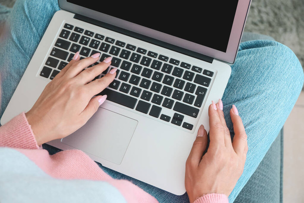 Молода жінка працює на ноутбуці вдома, крупним планом
 - Фото, зображення