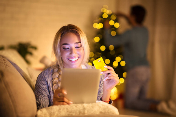 Mladá žena hledá vánoční dárky na tablet - Fotografie, Obrázek