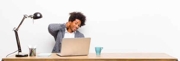 young black businessman laughing cheerfully and confidently with a casual, happy, friendly smile on a desk - Foto, Imagen