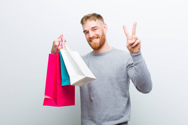 young red head man with shopping bags against white background - Φωτογραφία, εικόνα