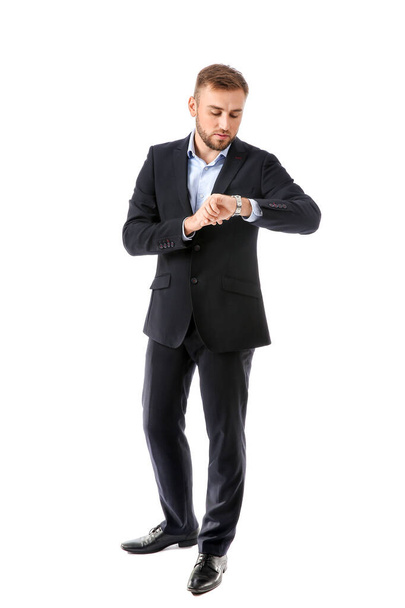 Portrait of handsome businessman looking at watch on white background - Foto, Imagem