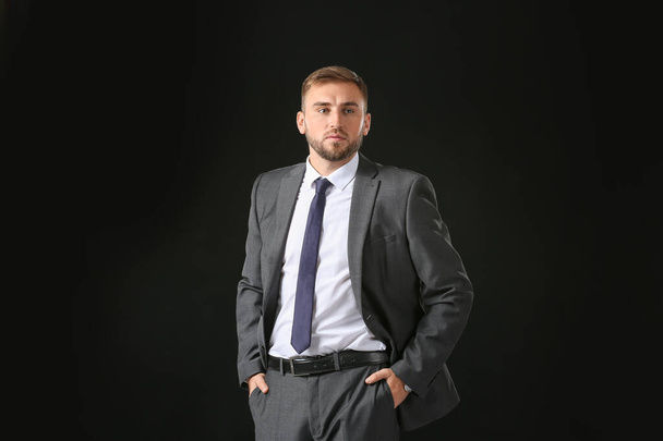 Portrait of handsome businessman on dark background - Foto, afbeelding