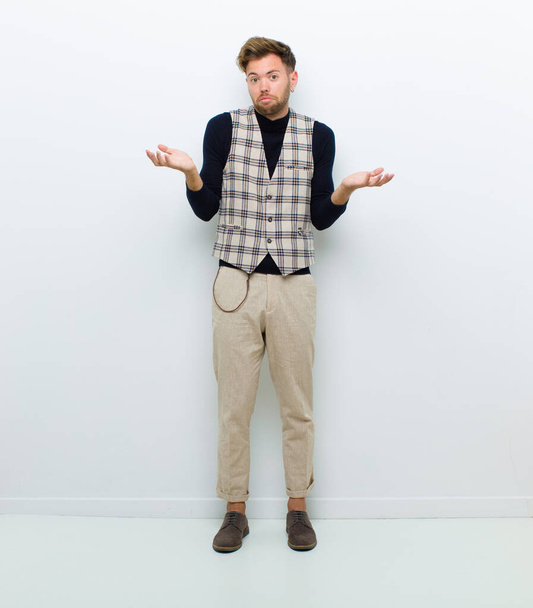 young full body man feeling clueless and confused, not sure which choice or option to pick, wondering against white background - 写真・画像