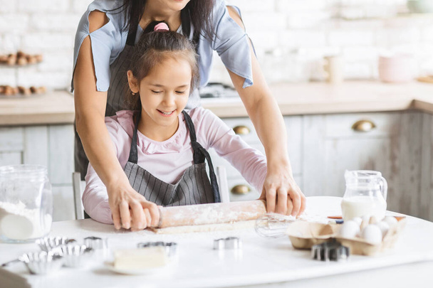 Mère aidant fille à utiliser rouleau à pâtisserie
. - Photo, image