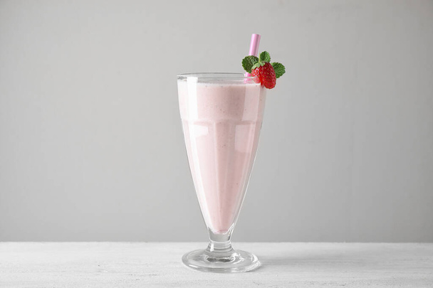 Tasty strawberry milk shake in glass on white wooden table - Fotoğraf, Görsel