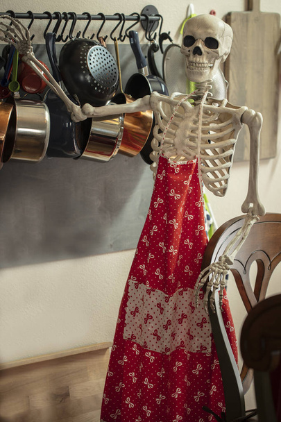 台所のハロウィーンの骨格は食べ物を準備する準備をする  - 写真・画像