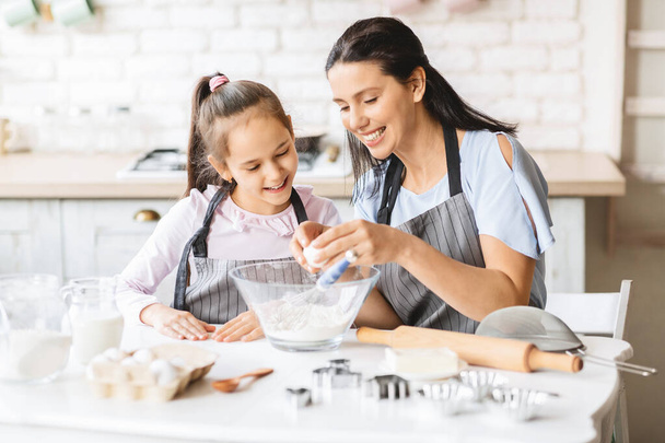 Happy mother teaching her daughter preparing food - Photo, Image
