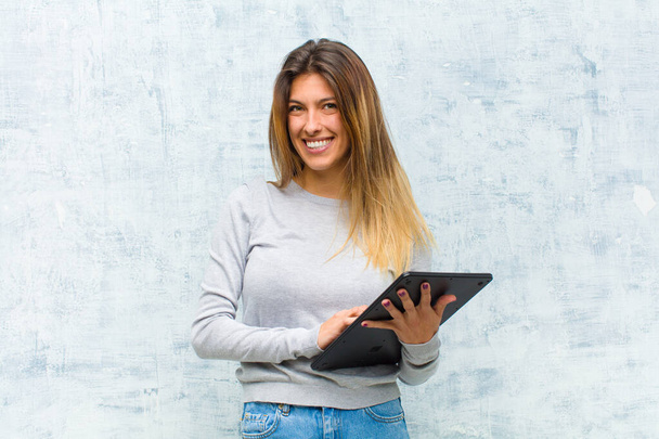 young pretty woman with a tablet against grunge wall - Foto, imagen