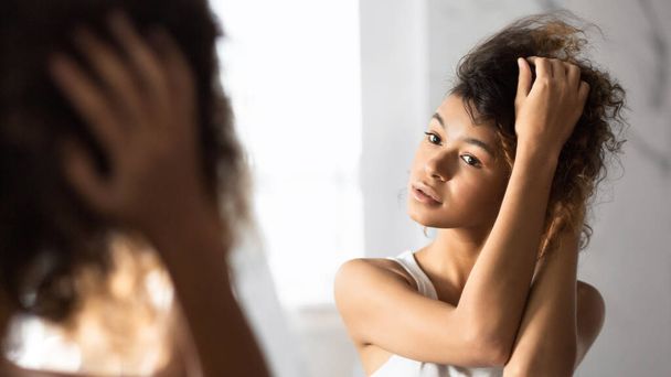 Afro Woman Touching Hair Looking In Mirror In Bathroom, Panorama - Foto, Imagem