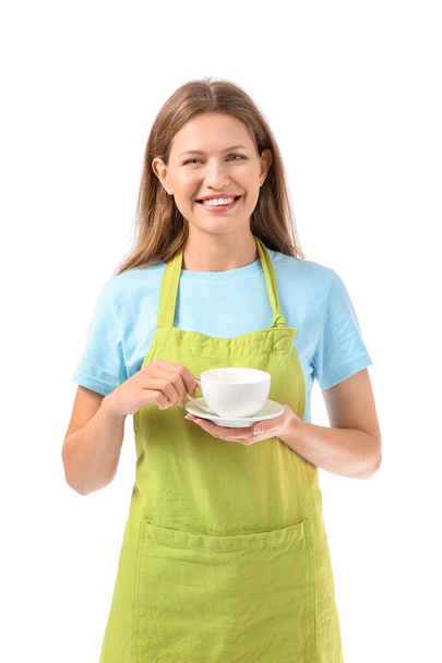 schöne junge Frau in Schürze und mit Tasse Kaffee auf weißem Hintergrund - Foto, Bild