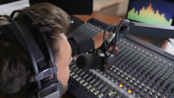 trabalho no rádio, homem com fones de ouvido na cabeça fala em microfone
 - Filmagem, Vídeo