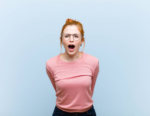 young red head pretty woman feeling terrified and shocked, with mouth wide open in surprise - Photo, Image