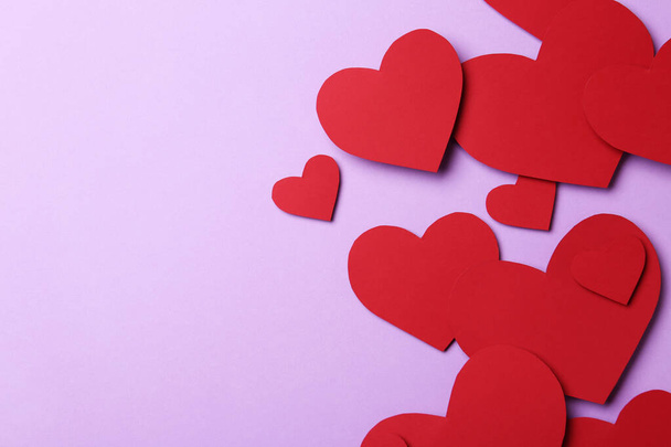 Red paper hearts on violet background, flat lay. Space for text - Fotografie, Obrázek