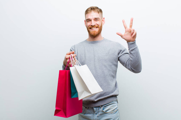 young red head man with shopping bags against white background - Фото, зображення