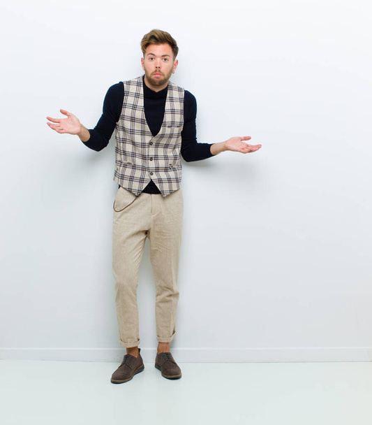 young full body man feeling clueless and confused, having no idea, absolutely puzzled with a dumb or foolish look against white background - Foto, Bild