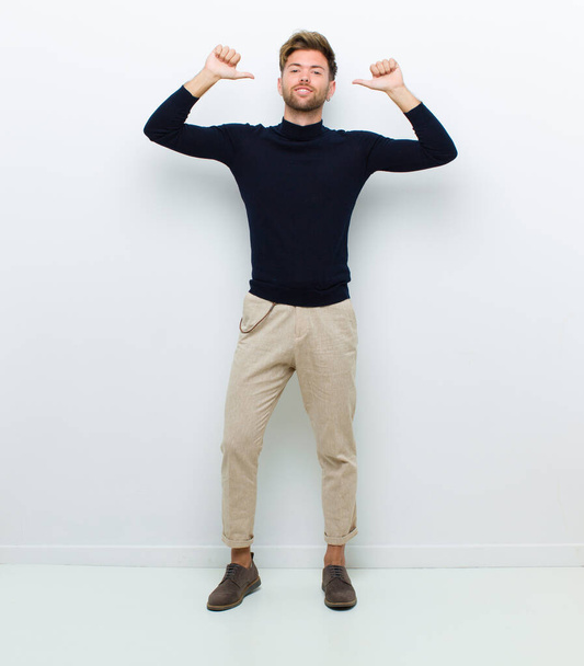 young full body man feeling proud, arrogant and confident, looking satisfied and successful, pointing to self against white background - 写真・画像