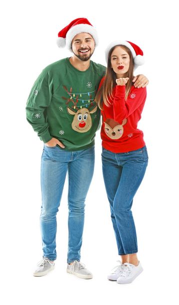 Happy young couple in Christmas clothes on white background - Foto, afbeelding