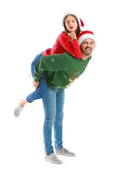 glückliches junges Paar in Weihnachtskleidung auf weißem Hintergrund - Foto, Bild