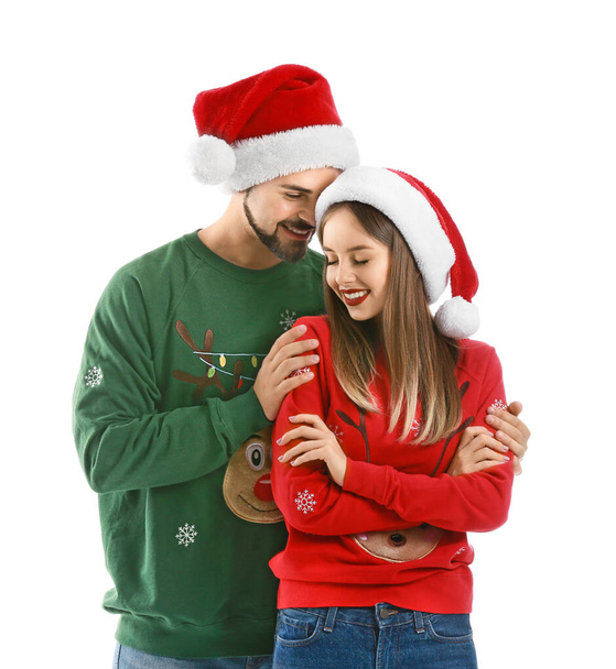 Happy young couple in Christmas clothes on white background - Fotó, kép