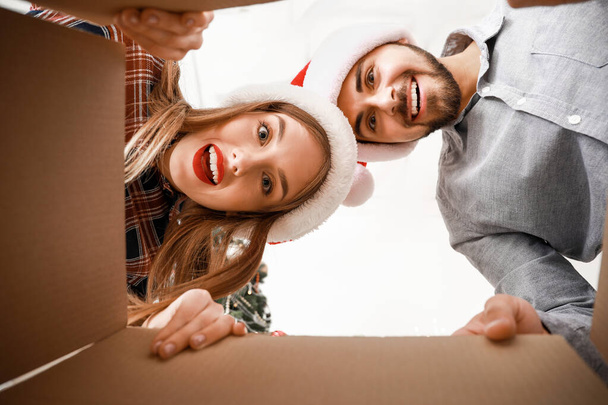 Happy young couple opening Christmas gift, view from the box - Photo, Image