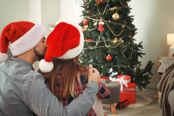 幸せな若いカップルお祝いクリスマス自宅で - 写真・画像
