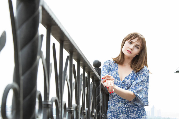 girl stands by a forged metal fence - Photo, Image