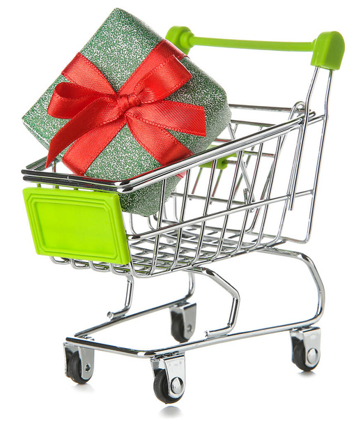 Pequeño carrito de compras con caja de regalo sobre fondo blanco
 - Foto, imagen