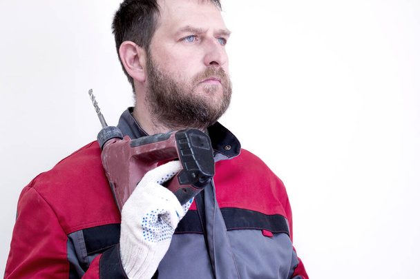 працівник в робочому одязі з бородою на плечі має електричний молоток
 - Фото, зображення
