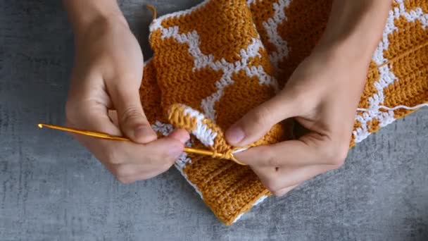大人女の子手かぎ針編みフックともにオレンジと白の綿の糸で石のテーブルの上の背景,上からのビューアップフルHDストックビデオビデオビデオのリアルタイム - 映像、動画