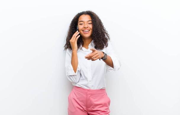 молода красива чорна жінка з смартфоном на білій стіні
 - Фото, зображення