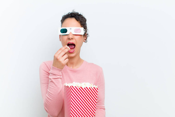 young pretty woman with pop corns and 3d glasses against white wall - Foto, Imagen
