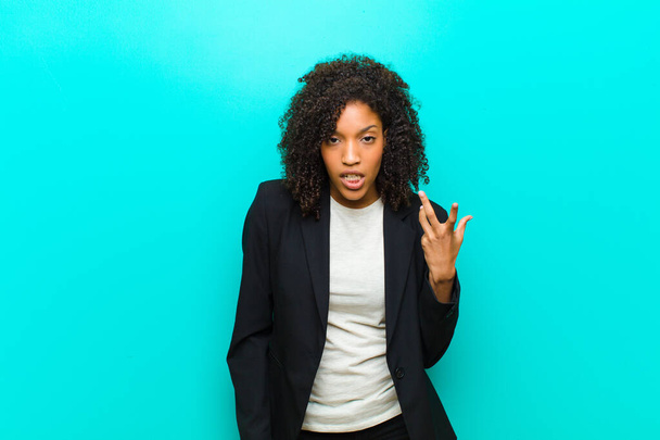 young black woman looking angry, annoyed and frustrated screaming wtf or whats wrong with you against blue wall  - Fotoğraf, Görsel
