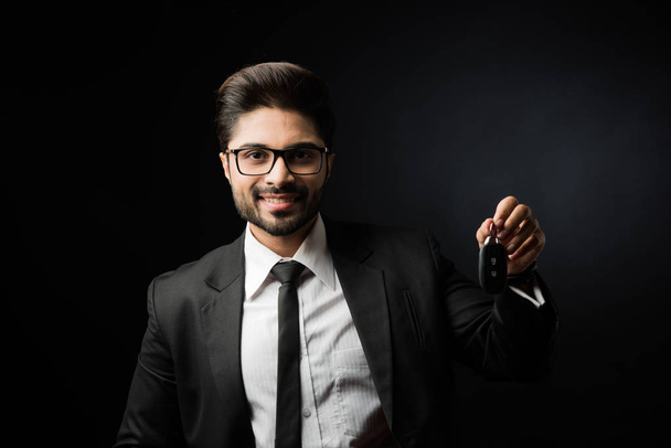 Indický podnikatel s klíčky od auta, stojící izolované nad černým pozadím - Fotografie, Obrázek