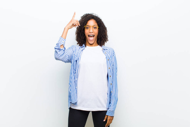 молода крута афроамериканка відчуває себе щасливою і схвильованою генієм після усвідомлення ідеї, весело піднімаючи палець, Еврика
! - Фото, зображення