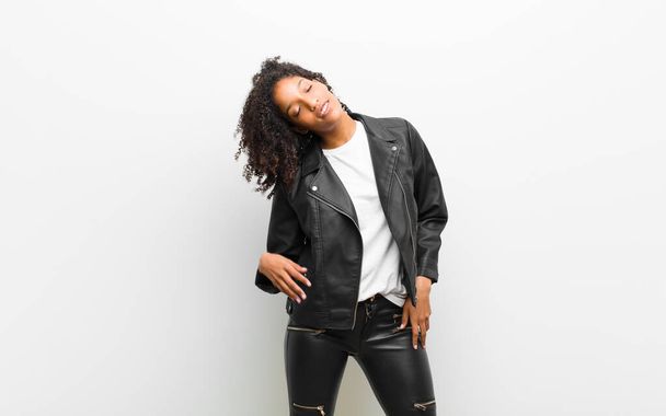 young pretty black woman wearing a leather jacket against white wall - Foto, Imagen