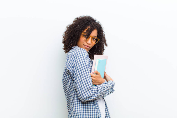young pretty black woman with books against white wall - Foto, Bild