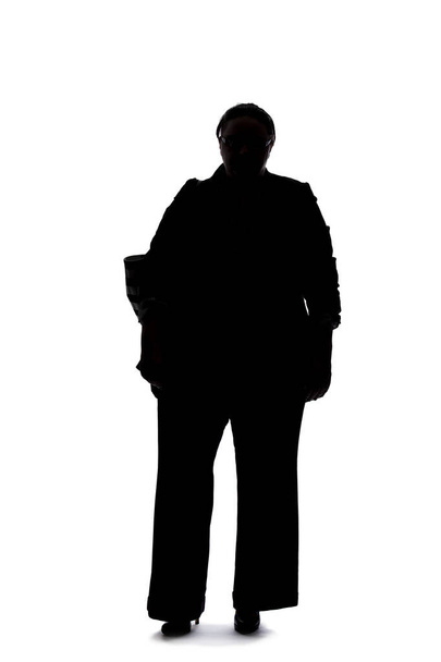 Silhouette of a curvy or plus size businesswoman on a white background.  She is posed like she is bored of waiting and standing. - Fotografie, Obrázek