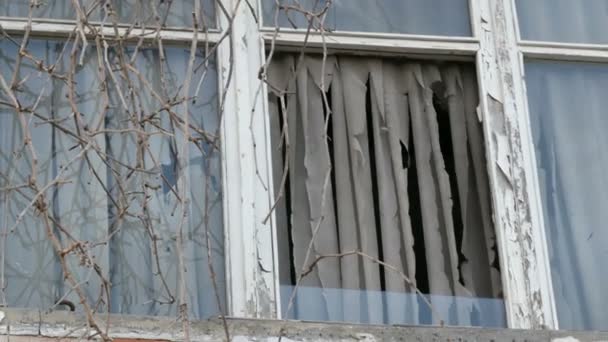 Zniszczony stary dom z postrzępionymi oknami i starymi zasłonami - Materiał filmowy, wideo