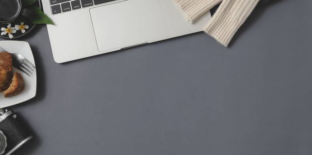 Вид сверху на зимнее рабочее пространство с ноутбуком и канцелярскими принадлежностями на сером фоне стола
  - Фото, изображение
