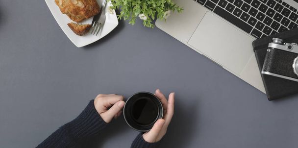 Top view of young female holding coffee cup in winter workspace  - Fotografie, Obrázek