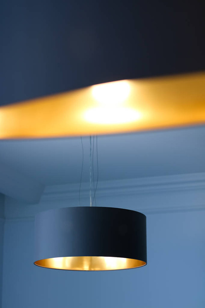 Goldene Lampe im Zimmer, elegante moderne Dekorbeleuchtung - Foto, Bild