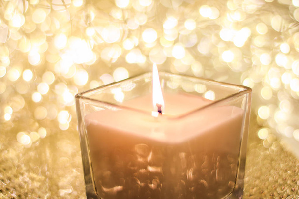 Aromatic candle on golden Christmas and New Years glitter backgr - Photo, Image