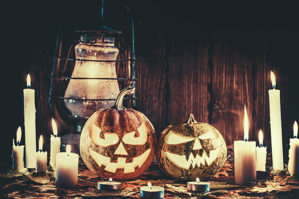 Halloween pumpkin with glowing face on a wooden background with  - Foto, afbeelding
