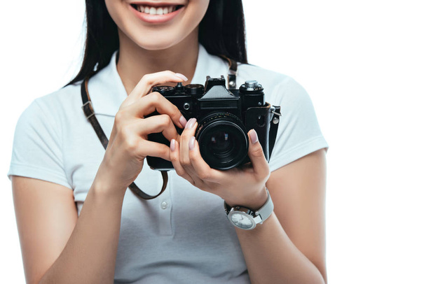 περικοπή άποψη του χαμογελαστού μελαχρινή ασιατική γυναίκα λήψη φωτογραφιών σε ψηφιακή φωτογραφική μηχανή που απομονώνονται σε λευκό - Φωτογραφία, εικόνα