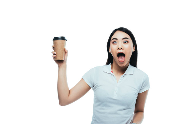 impactado atractivo asiático chica con abierto boca celebración papel taza aislado en blanco
 - Foto, imagen