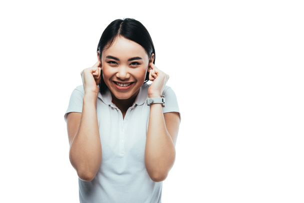 happy attractive asian girl putting fingers in ears isolated on white - Фото, изображение