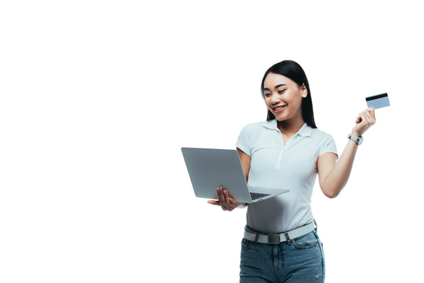 heureux attrayant asiatique fille tenant carte de crédit et ordinateur portable isolé sur blanc
 - Photo, image