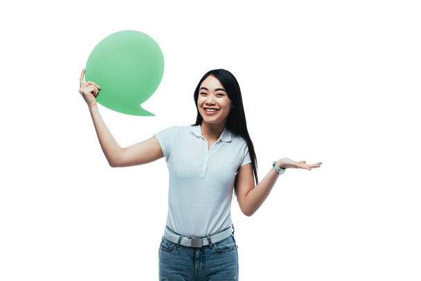 happy attractive asian girl holding green blank speech bubble isolated on white - Foto, immagini