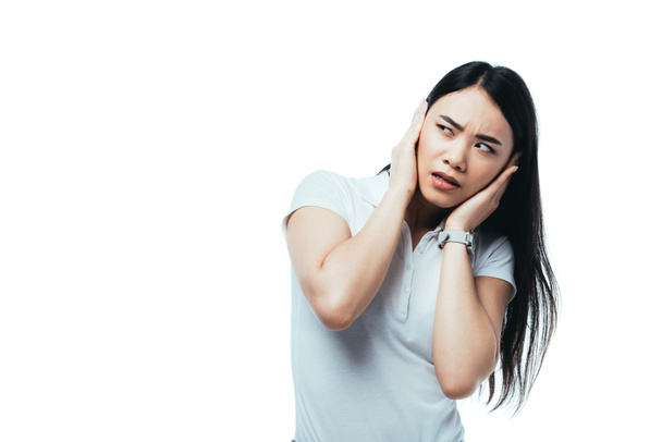 confused attractive asian girl covering ears with hands isolated on white - Fotografie, Obrázek