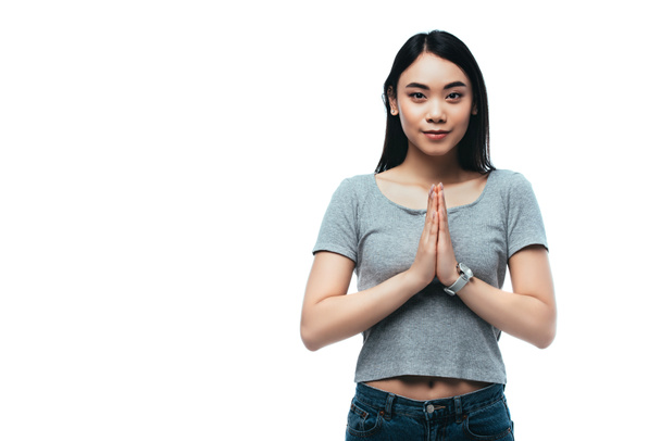 uśmiechnięta Azjatka dziewczyna z modlącymi się rękami odizolowany na biały - Zdjęcie, obraz
